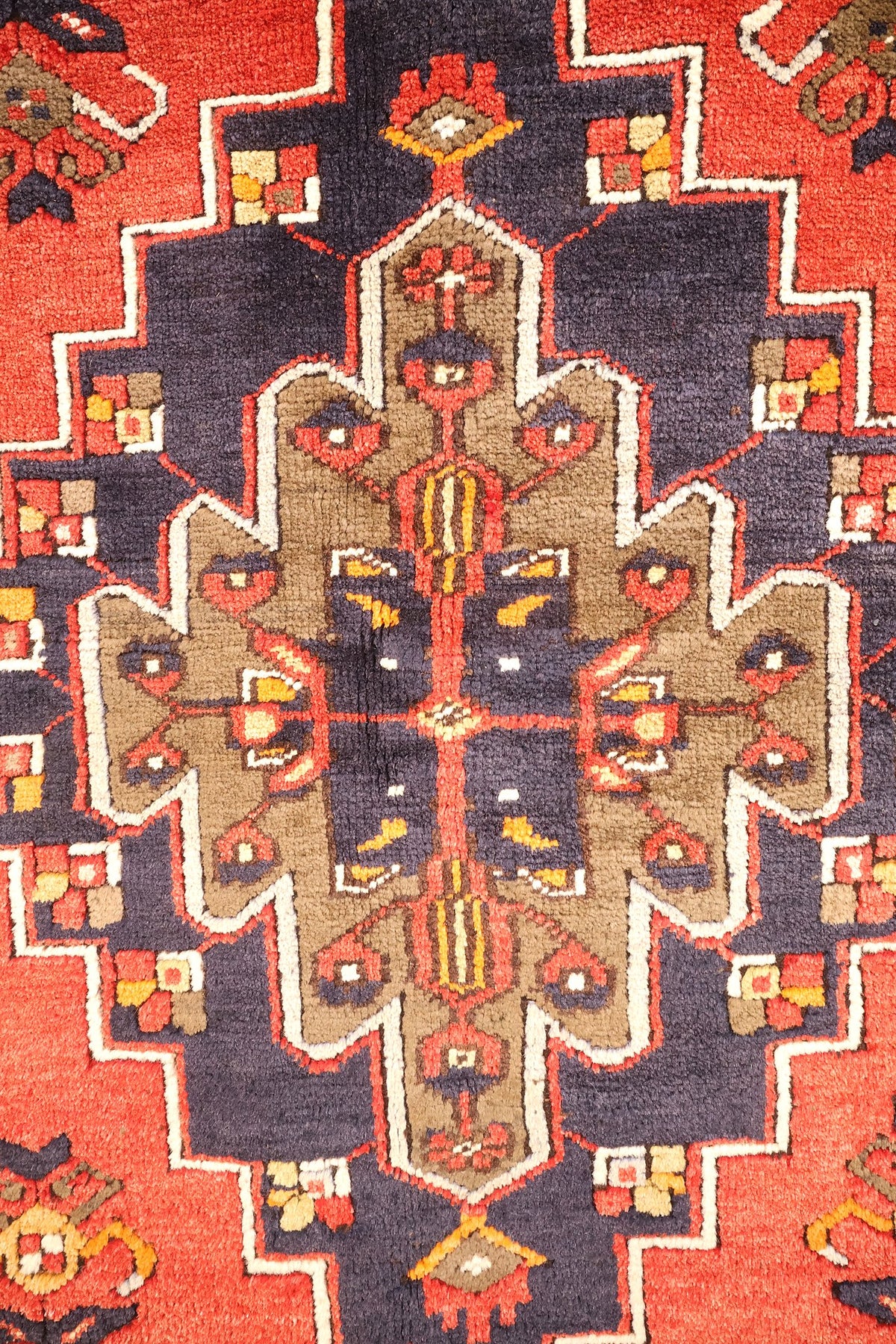 Détail du médaillon crénelé bleu nuit à cœur brun fleuri du tapis Yahyali