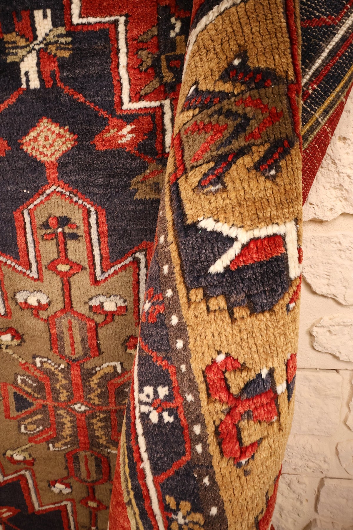 Coin replié du tapis Yahyali rouge, motifs crantés de la bordure en relief