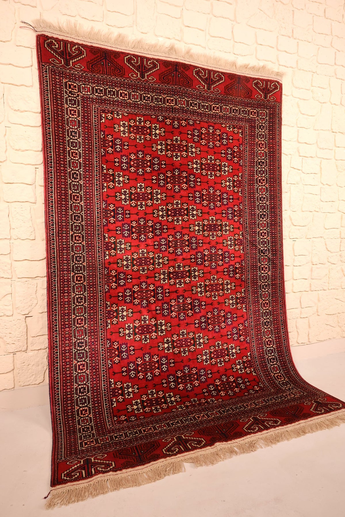 Tapis Yomut rectangulaire en laine, vue de biais révélant les bordures concentriques