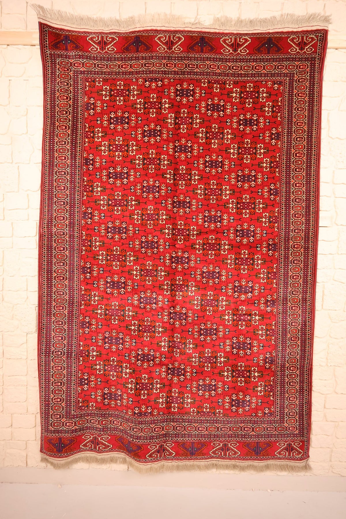 Tapis Yomut rouge 250 × 160 cm, vue d'ensemble avec semis de motifs et franges claires