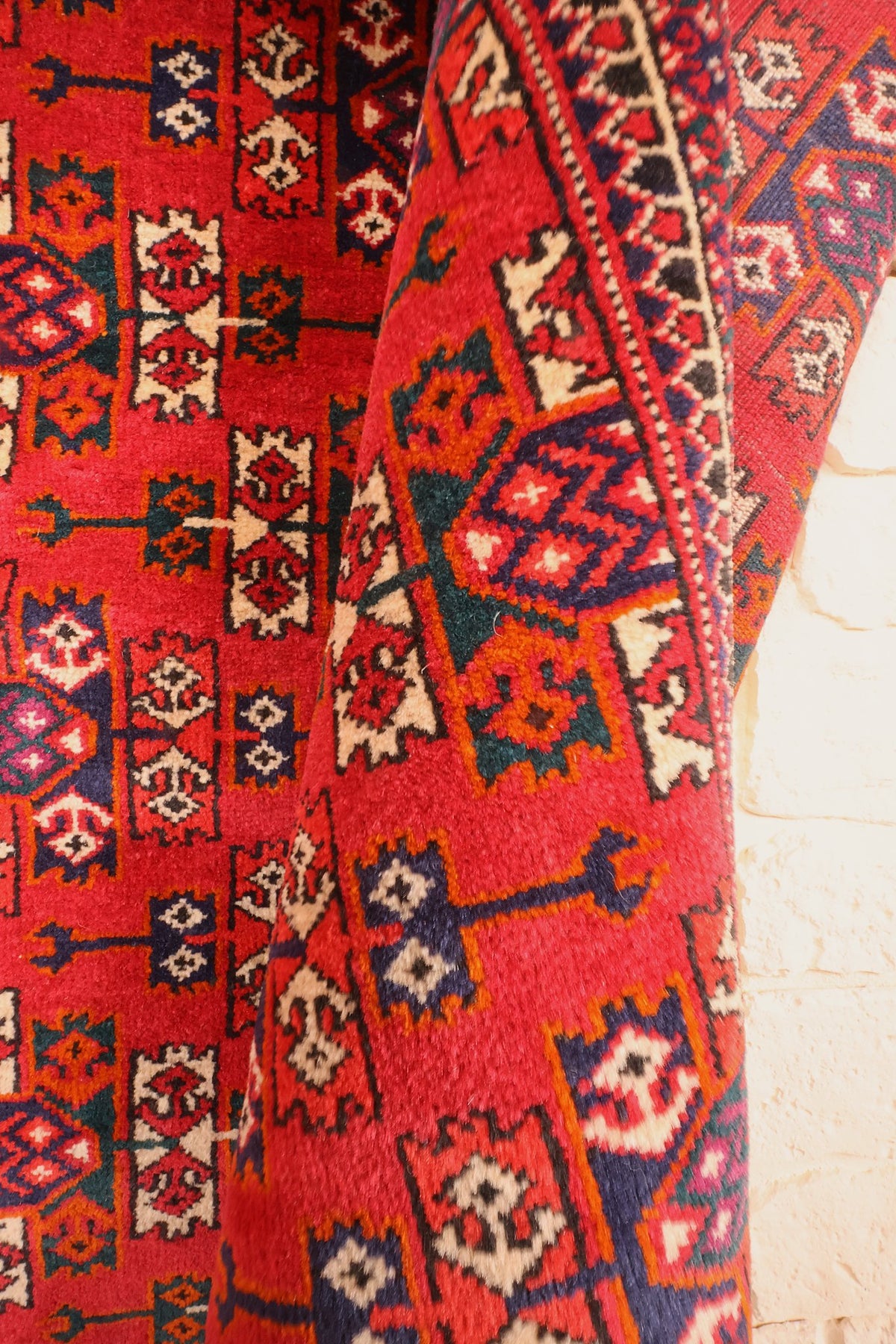 Coin replié du tapis Yomut en laine, motifs anguleux orange et bleu de près