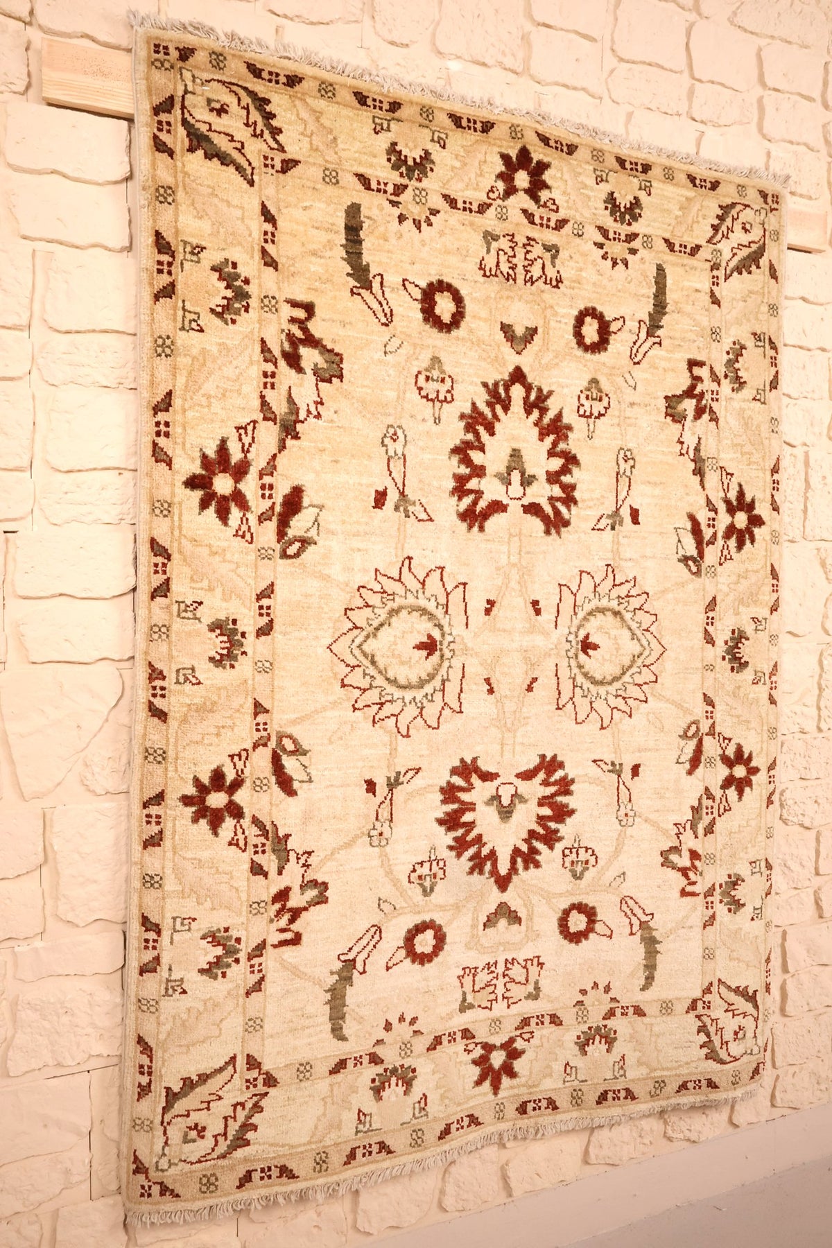 Tapis Ziegler beige et rouge vu de biais, bordure fleurie et franges claires
