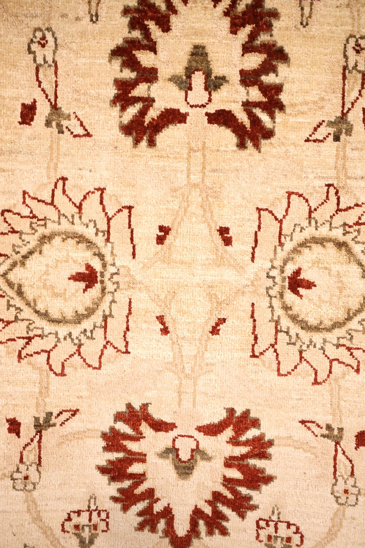 Détail des palmettes rouges et rosettes vert-gris du tapis Ziegler beige