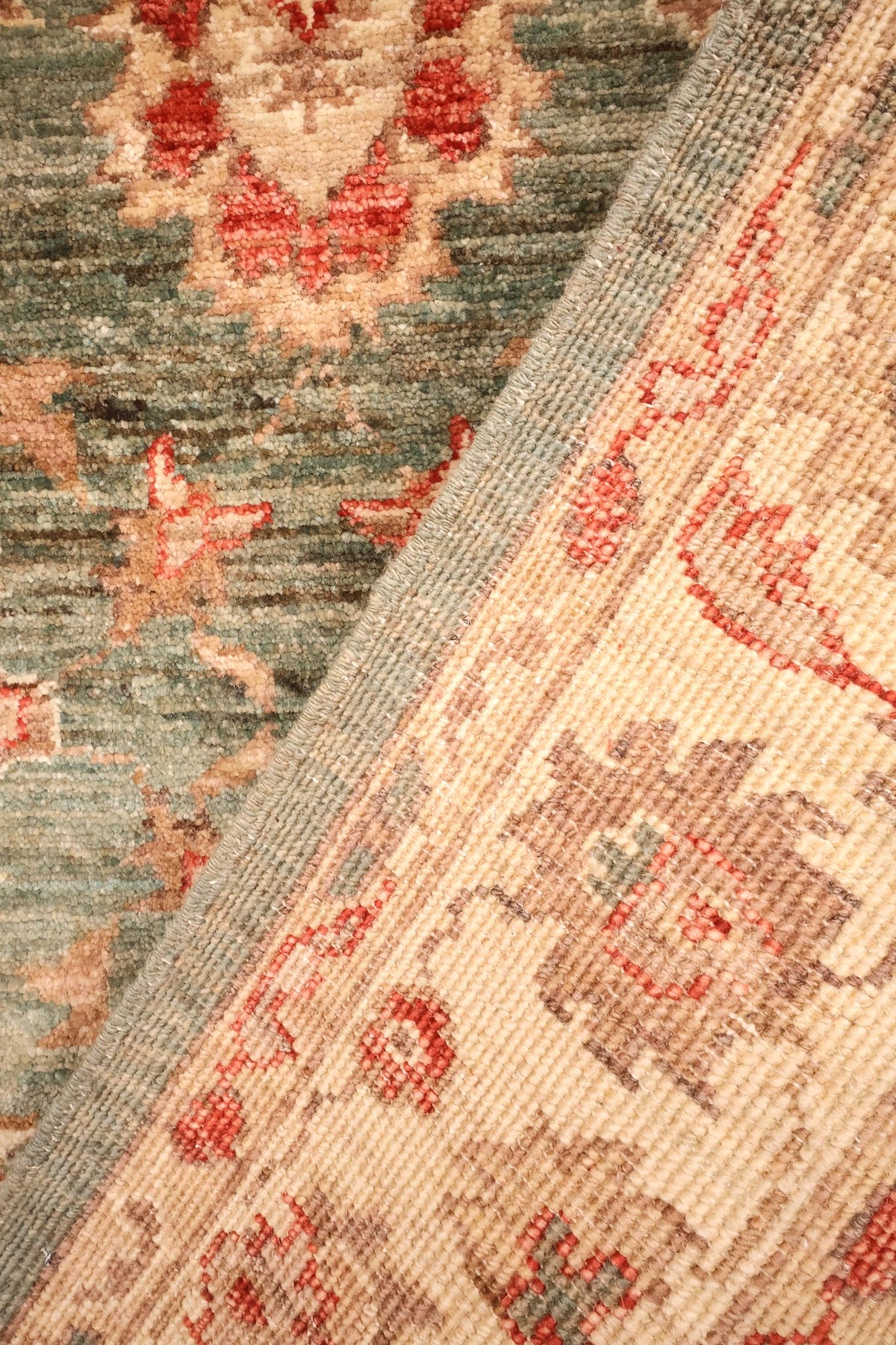 Coin replié du tapis Ziegler, nouage main visible au dos de la bordure