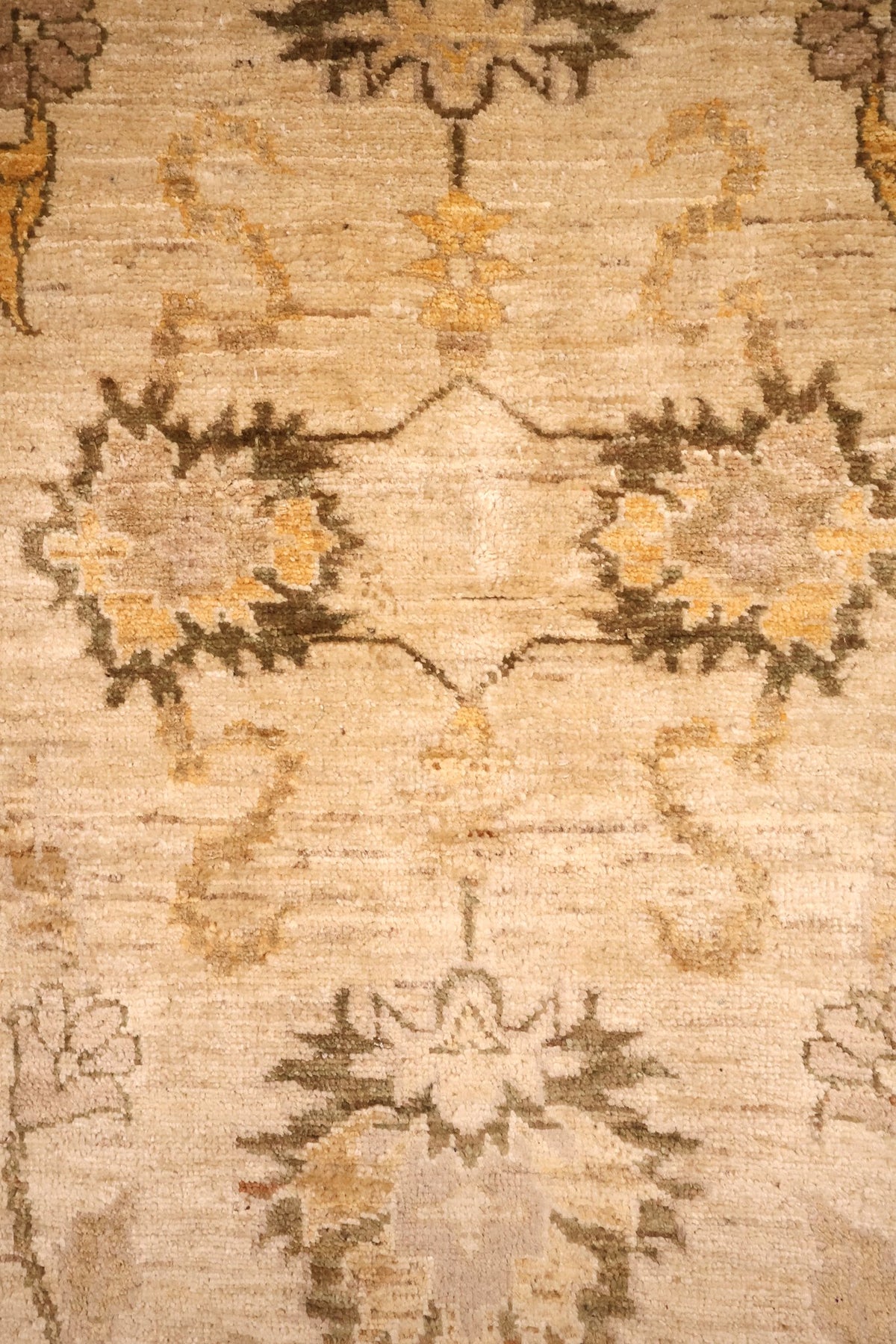 Détail des palmettes dentelées brun-vert et jaune sur champ beige du tapis Ziegler