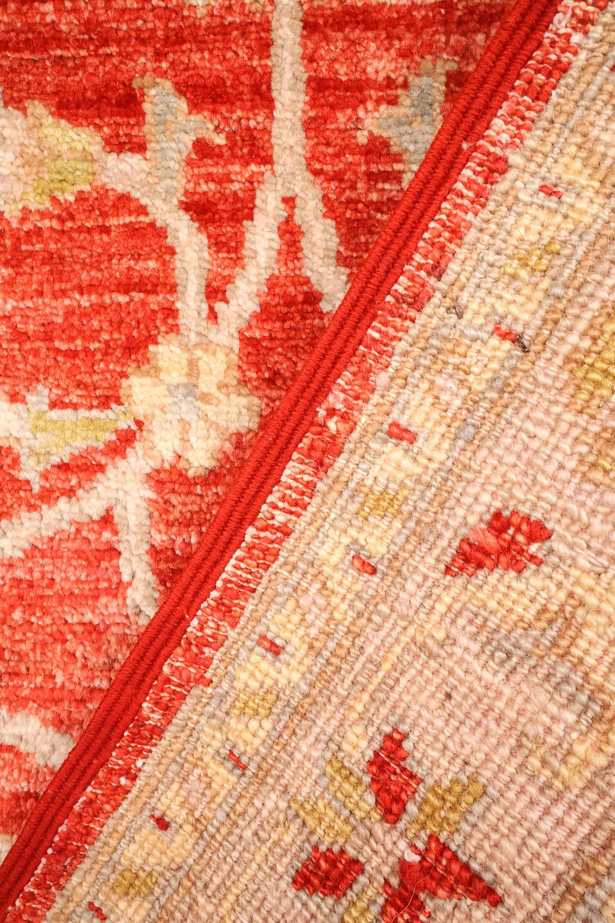 Coin replié du tapis Ziegler, lisière rouge et laine nouée visible