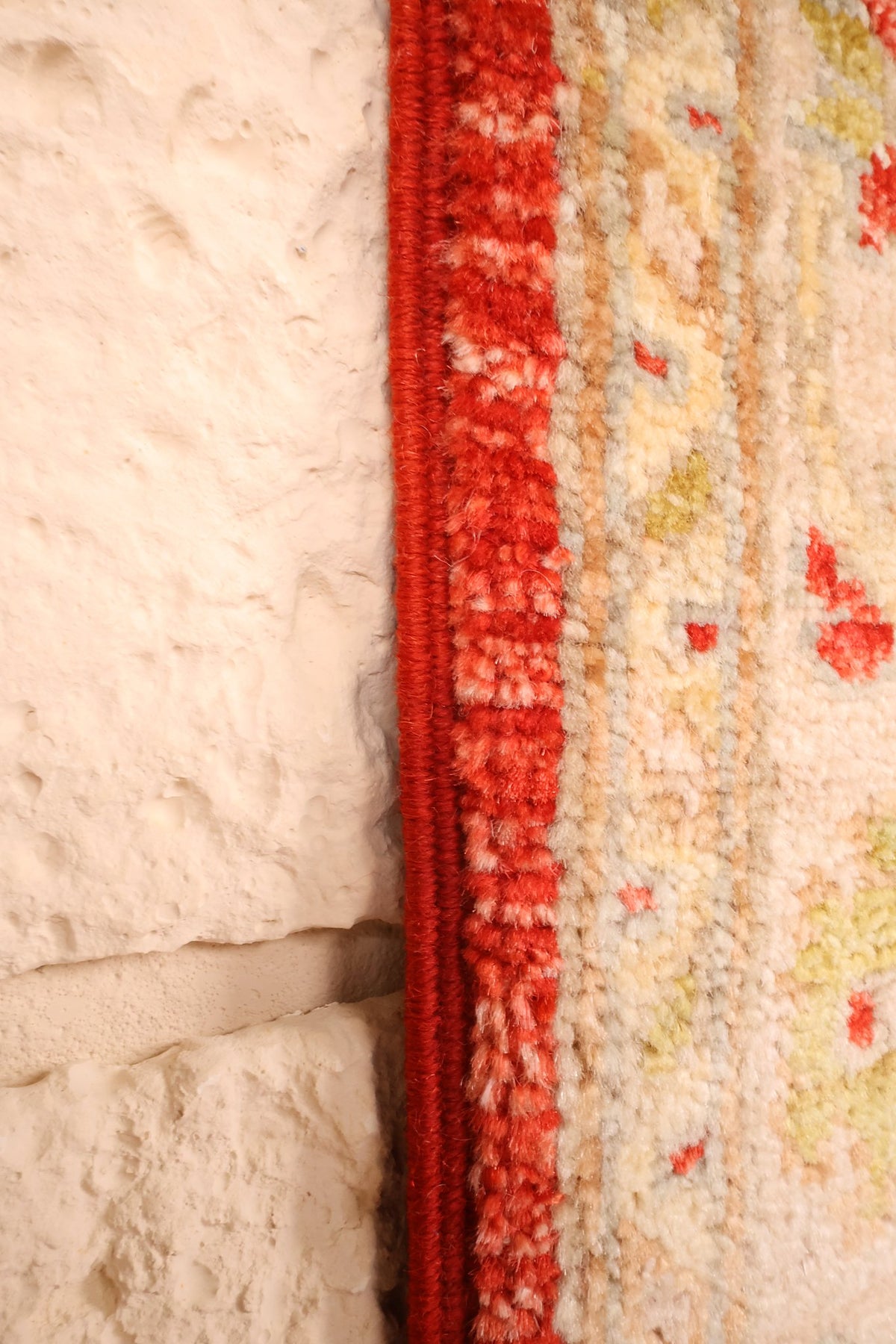 Lisière rouge du tapis Ziegler, bordure claire mouchetée de rouge et vert